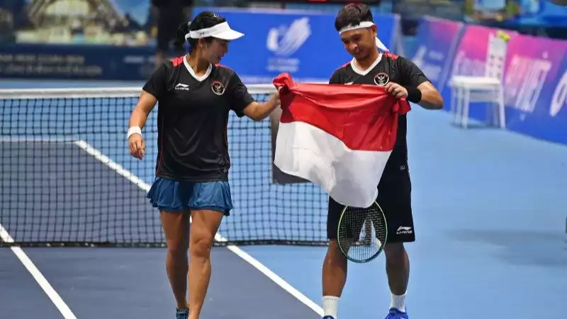 Petenis Indonesia Aldila Sutjiadi (kiri) dan Christopher Rungkat (kanan) membawa bendera Merah Putih usai mengalahkan lawannya asal Thailand Patcharin Cheapchandej dan Pruchya Isaro.