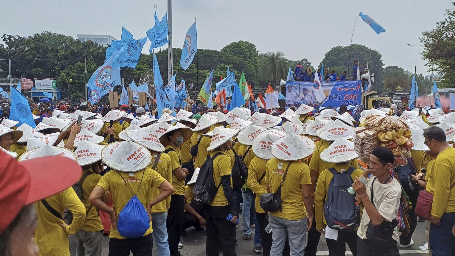 Kelompok Buruh Kenakan Topi Caping Dalam Peringatan Hari Buruh di Patung Kuda