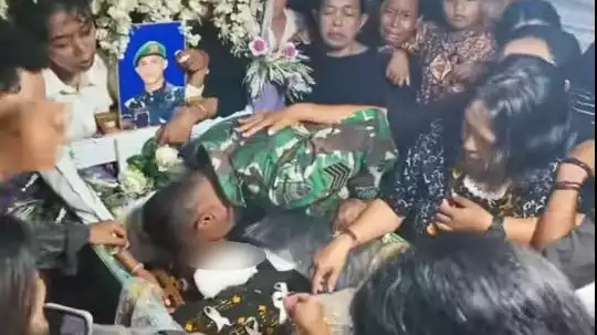 Ayah Prada Lucky, Sersan Mayor Cristian Namo mencium jenazah anaknya