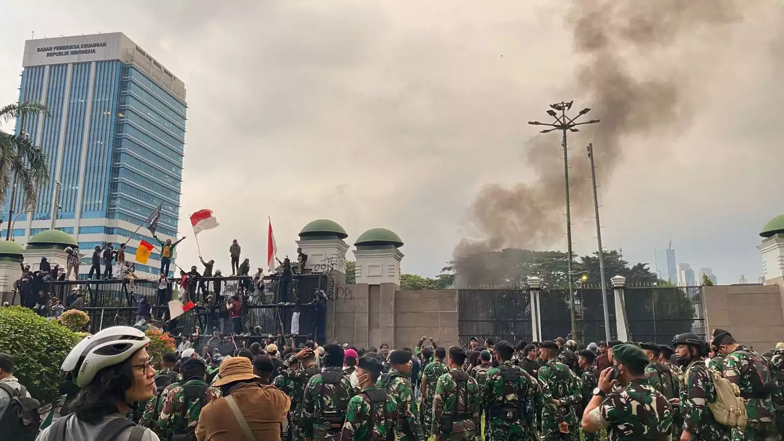 Situasi rusuh yang memperlihatkan massa yang berhasil menaiki pagar tinggi kompleks Gedung DPR RI, Jumat (29/8/2025) sore,