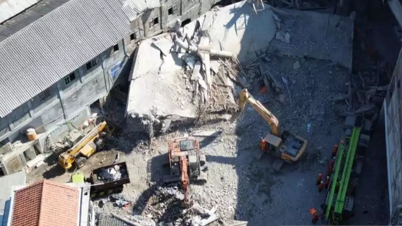 Gambar udara kondisi pengangkatan puing-puing bangunan tiga lantai Ponpes Al Khoziny yang runtuh menggunakan alat berat di Sidoarjo, Senin (6/10).