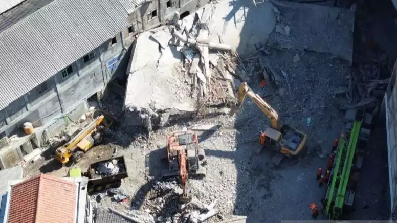 Gambar udara kondisi pengangkatan puing-puing bangunan tiga lantai Ponpes Al Khoziny yang runtuh menggunakan alat berat di Sidoarjo, Senin (6/10).