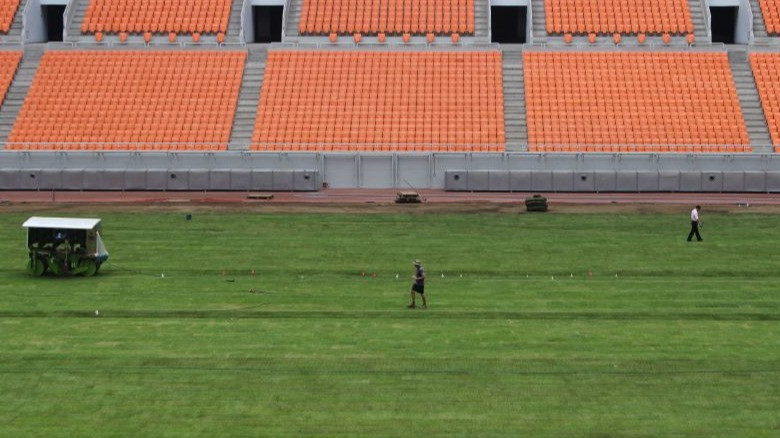 Pekerja memeriksa rumput Jakarta Internasional Stadium (JIS) di Jakarta, Kamis (19/10/2023).