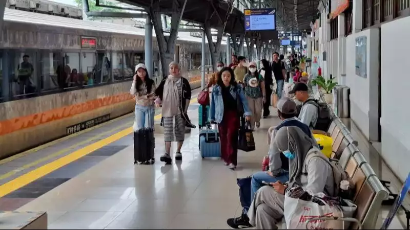 Sejumlah penumpang berjalan di samping kereta api.