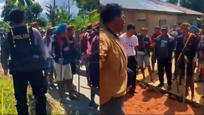 Anggota polisi berlutut untuk memisahkan dua kelompok yang nyaris bentrok