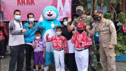 Coba Tarik Minat Anak untuk Divaksin, Anggota Polres Probolinggo Kenakan Kostum Doraemon