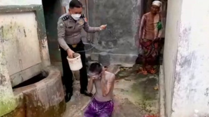 Akibat Sekujur Tubuh Dipenuhi dengan Cat Warna Silver, Seorang Polisi Mandikan Remaja Pengamen Jalanan