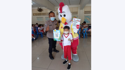 Polisi dan Pihak Sekolah Lakukan Vaksinasi Anak dengan Badut Penghibur