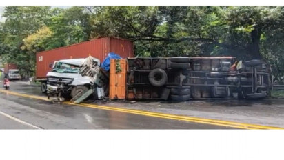 Tidak Kuat Menanjak, Sebuah Truk Terbalik dan Menabrak Kontainer di Belakangnya