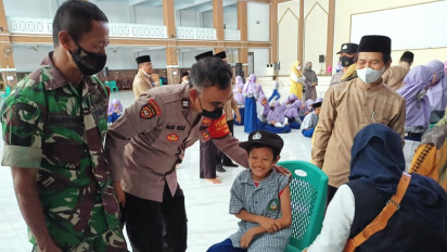 Lucu, Seorang Siswa Pinjam Topi Polisi agar Tak Takut saat Disuntik Vaksin Covid-19