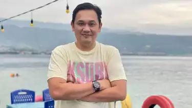 Foto Farhat Abbas berpose dengan background laut
