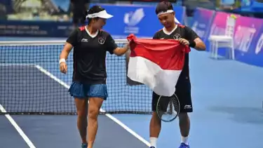 Petenis Indonesia Aldila Sutjiadi (kiri) dan Christopher Rungkat (kanan) membawa bendera Merah Putih usai mengalahkan lawannya asal Thailand Patcharin Cheapchandej dan Pruchya Isaro.