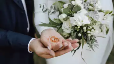 The bride holds a wedding bouquet in her hands