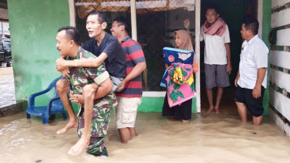 Anggota TNI Kodim Tanggamus Evakuasi Korban Banjir yang Sedang Sakit