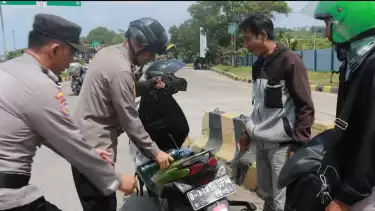 Kapolsek KSKP Bakauheni, AKP Ridho Rafika saat membantu pemudik yang kehabisan bensin.