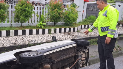 Melaju Kencang, Mobil Sedan Terjun di Saluran Air