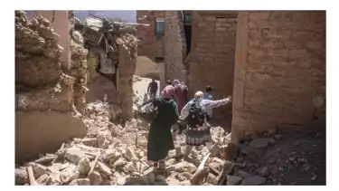 Warga Desa Moulay Brahim, di luar Marakech, melihat puing-puing rumah mereka (9/9/2023).