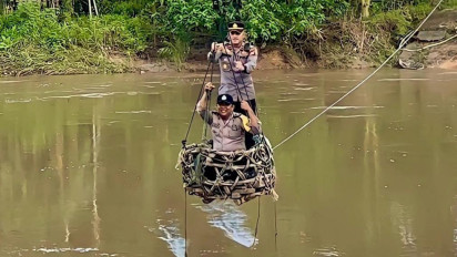 Sosialisasikan Pemilu Damai di Desa Terisolir, Personel Polres Rokan Hulu Gunakan Keranjang Terbang