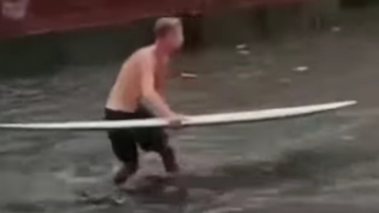 Aksi Bule Mai Surfing Saat Banjir di Jalan Pantai Kuta
            - galeri foto