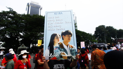 Momen Buruh Bawa Poster Nyeleneh saat Demo Hari Buruh di Patung Kuda, Singgung Kurangi Bekerja Perbanyak Bercinta