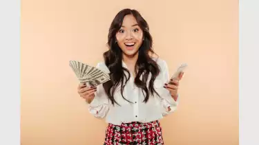 Wanita Asia tersenyum memegang uang