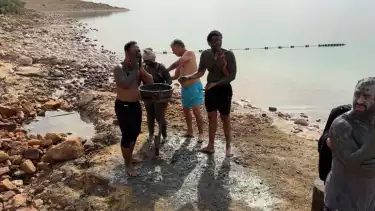 Wisatawan luluran menggunakan lumpur Laut Mati yang dipercaya baik untuk kulit.