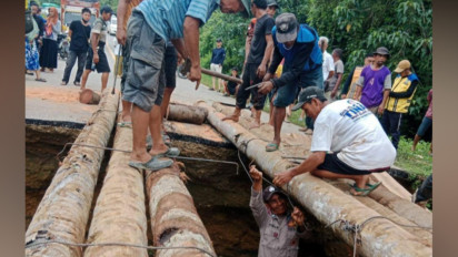 Jalan Amblas di Konawe Selatan, Polisi dan Warga Buat Jembatan Darurat dari Batang Kelapa