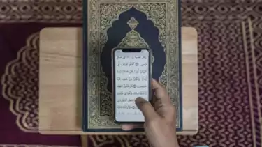 Ilustrasi membaca Al Quran dari HP