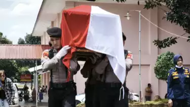 Personel kepolisian sedang mengangkut jenazah anggota polri yang meninggal dunia saat melakukan penggerebekan judi sabung ayam