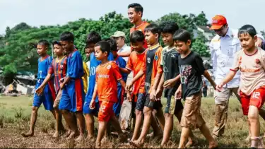 Rizky Ridho bermain sepak bola dengan anak-anak