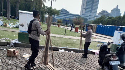 Personel Polri Ikut Serta Bersih-bersih Kawasan Monas Usai Kegiatan May Day Fiesta