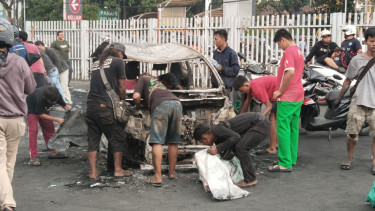 Warga Preteli Bangkai Mobil yang Hangus Dibakar Massa di Depan Polres Jakarta Timur