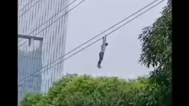 Pria nekat bergelantungan di kabel di Jalan Gatot Subroto, Karet Kuningan, Setiabudi, Jakarta Selatan.