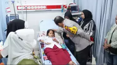 Kapolda Metro Jaya Irjen Pol Asep Edi Suheri berkomunikasi dengan siswi SDN Kalibaru 01 Cilincing, Jakarta Utara, yang mendapatkan perawatan medis akibat ditabrak mobil pengantar makanan di halaman sekolah, Kamis (11/12/2025).